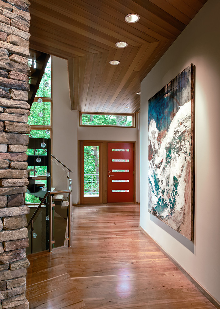 Photo of a large contemporary entryway in Detroit with red walls, light hardwood floors, a single front door and a red front door.