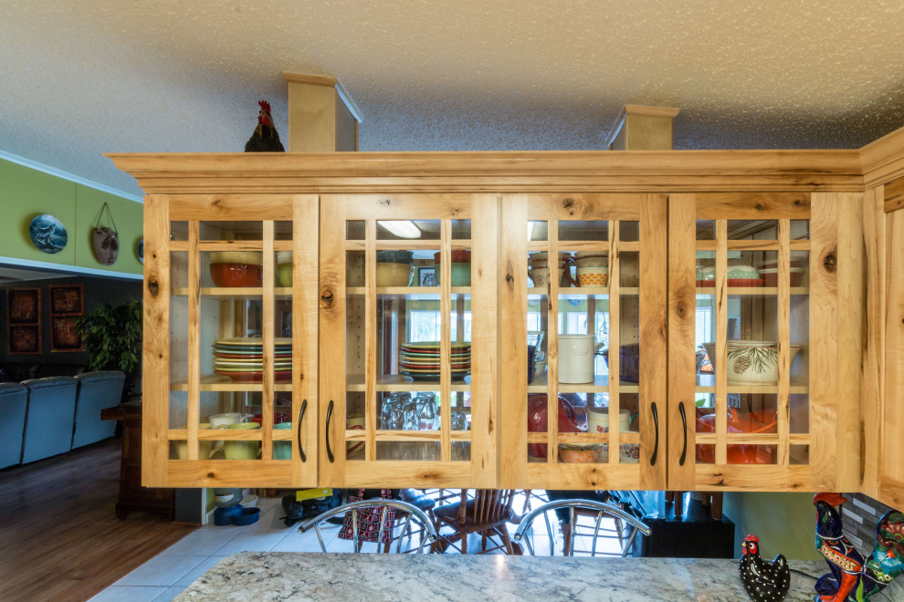 Eat-in kitchen - mid-sized u-shaped cement tile floor and beige floor eat-in kitchen idea with an undermount sink, shaker cabinets, light wood cabinets, granite countertops, glass tile backsplash, black appliances, a peninsula and beige countertops