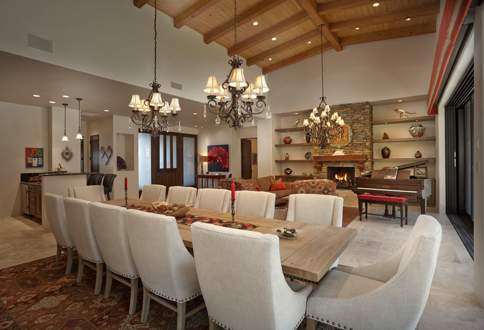 Photo of a large open plan dining in Phoenix with beige walls, travertine floors, a standard fireplace and a stone fireplace surround.