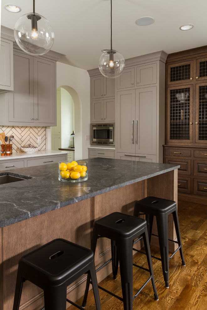 Photo of a large transitional eat-in kitchen in Minneapolis with an undermount sink, shaker cabinets, beige splashback, panelled appliances, dark hardwood floors, with island and brown floor.