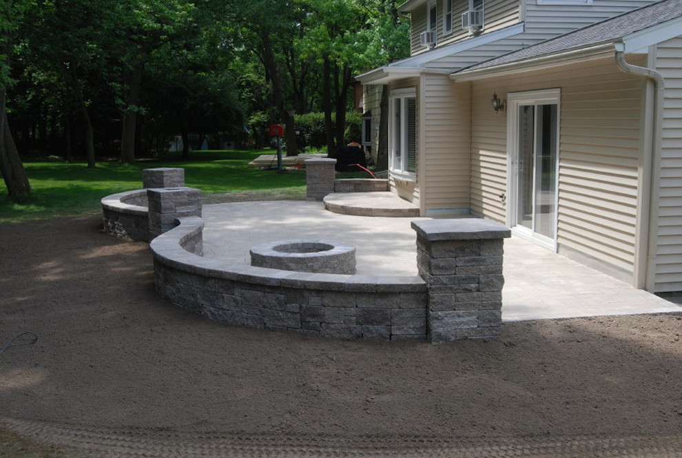 Photo of a large traditional backyard patio in New York with a fire feature, brick pavers and an awning.