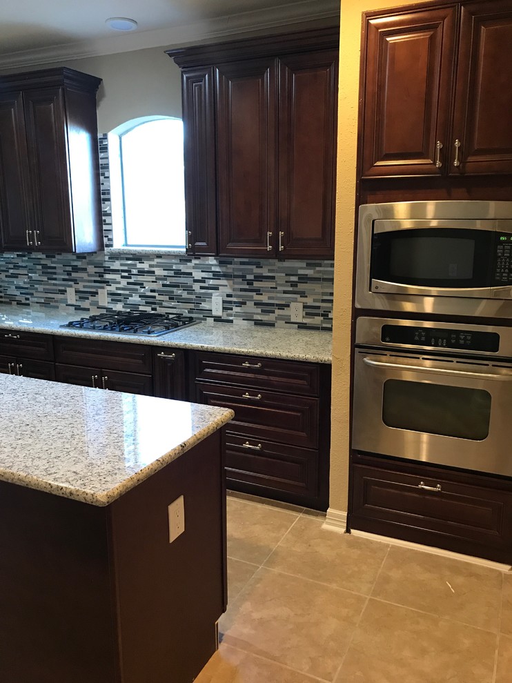 Inspiration for a mid-sized transitional u-shaped porcelain tile and beige floor enclosed kitchen remodel in Houston with raised-panel cabinets, dark wood cabinets, quartzite countertops, multicolored backsplash, matchstick tile backsplash, stainless steel appliances and an island