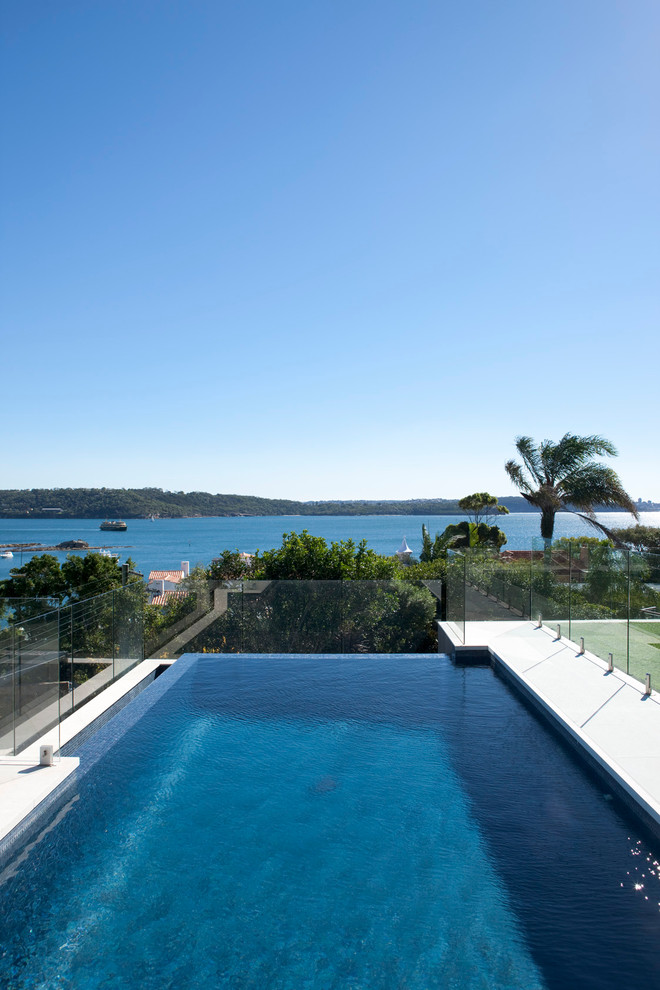 Expansive contemporary backyard custom-shaped infinity pool in Sydney.