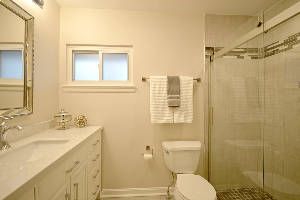 Inspiration for a mid-sized transitional master bathroom in DC Metro with shaker cabinets, white cabinets, a curbless shower, a two-piece toilet, gray tile, ceramic tile, beige walls, ceramic floors, an undermount sink and marble benchtops.