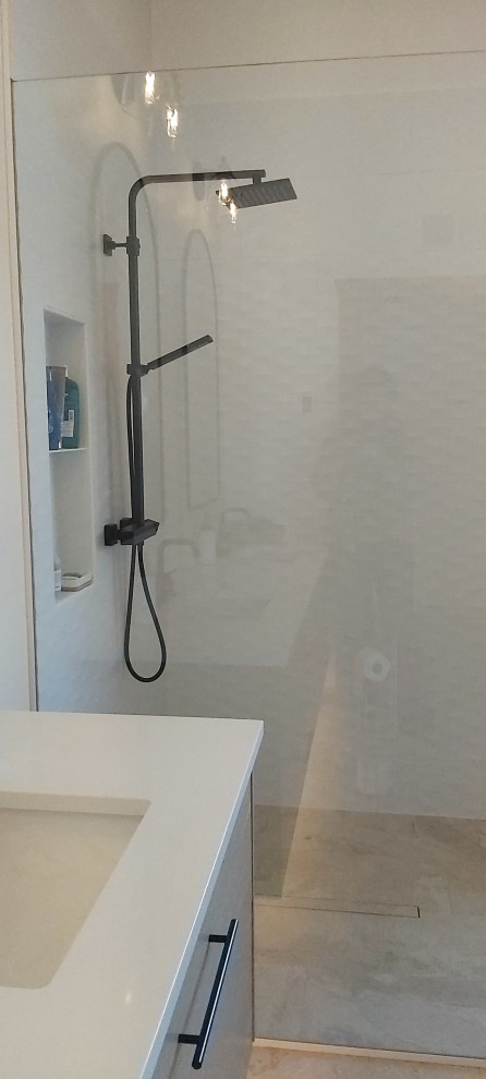 Foto på ett mellanstort minimalistiskt vit en-suite badrum, med släta luckor, skåp i ljust trä, en kantlös dusch, en toalettstol med separat cisternkåpa, vit kakel, vita väggar, klinkergolv i porslin, ett undermonterad handfat, bänkskiva i kvarts, beiget golv och med dusch som är öppen