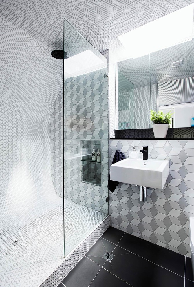 Design ideas for a contemporary bathroom in Los Angeles with an alcove shower, gray tile, a wall-mount sink and black floor.