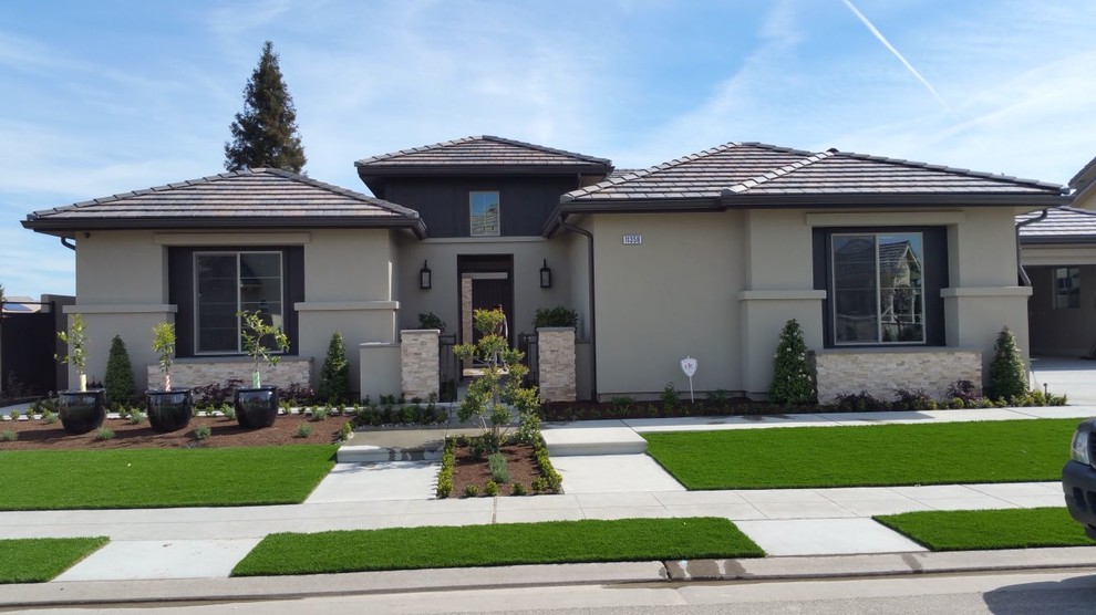 Inspiration for a large transitional beige one-story stucco gable roof remodel with a tile roof