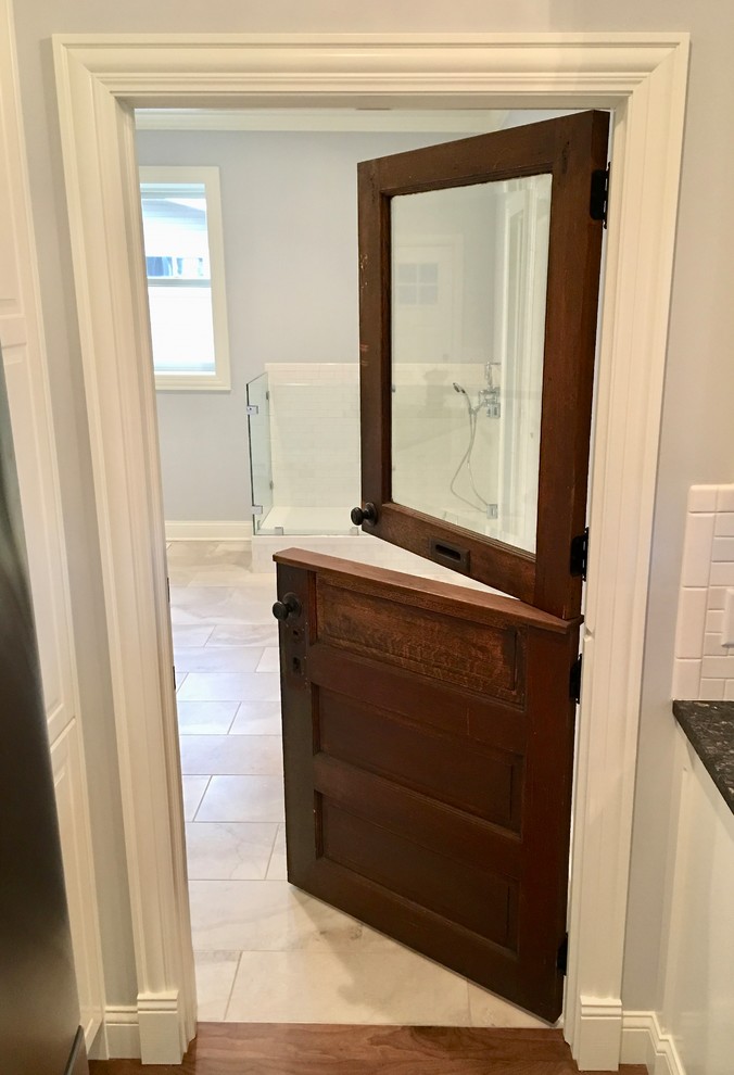 Photo of a large country galley utility room in Austin with raised-panel cabinets, white cabinets, granite benchtops, grey walls, porcelain floors, a side-by-side washer and dryer, multi-coloured floor and blue benchtop.