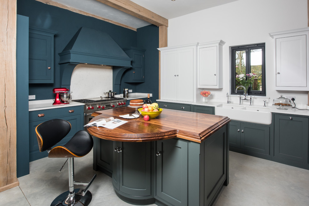 Photo of a mid-sized transitional l-shaped open plan kitchen in Essex with black appliances, multiple islands, beige benchtop, a farmhouse sink, recessed-panel cabinets, grey cabinets, concrete floors and grey floor.
