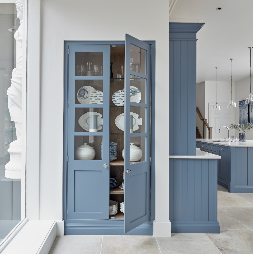 Inspiration for a large traditional l-shaped eat-in kitchen in Gloucestershire with an undermount sink, shaker cabinets, blue cabinets, quartz benchtops, white splashback, mirror splashback, stainless steel appliances, limestone floors, multiple islands, beige floor and white benchtop.