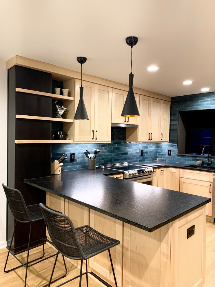 Example of a mid-sized transitional u-shaped light wood floor and brown floor eat-in kitchen design with an undermount sink, shaker cabinets, light wood cabinets, granite countertops, blue backsplash, ceramic backsplash, stainless steel appliances, a peninsula and black countertops