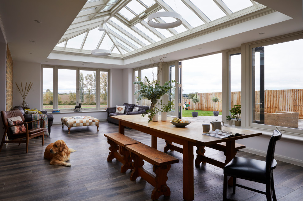Photo of a medium sized farmhouse conservatory in Essex with dark hardwood flooring, a skylight and brown floors.