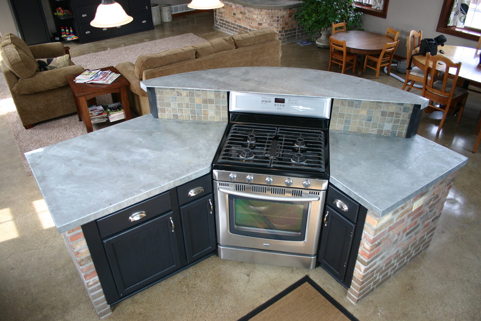 Example of a mid-sized transitional l-shaped concrete floor eat-in kitchen design in Orange County with shaker cabinets, black cabinets, concrete countertops, multicolored backsplash, stone tile backsplash, stainless steel appliances and an island