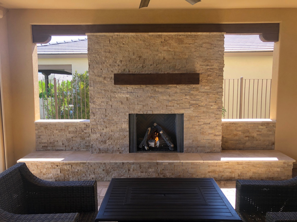 Example of a large transitional backyard stone patio design in Phoenix with a fireplace and a roof extension
