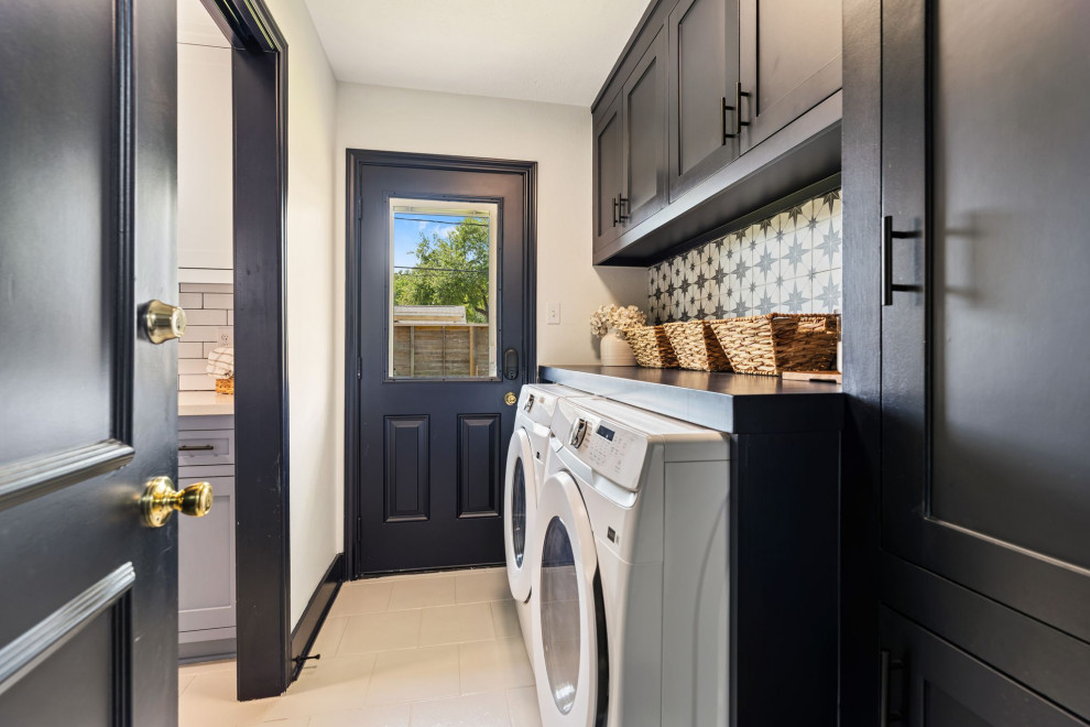 Transitional single-wall beige floor laundry room photo in Houston with shaker cabinets, black cabinets, white walls, a side-by-side washer/dryer and black countertops
