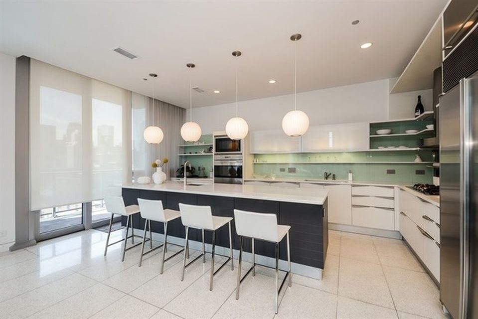 Photo of a large contemporary single-wall open plan kitchen in Chicago with a drop-in sink, white cabinets, blue splashback, stainless steel appliances, with island, flat-panel cabinets, granite benchtops, glass tile splashback, laminate floors and white floor.