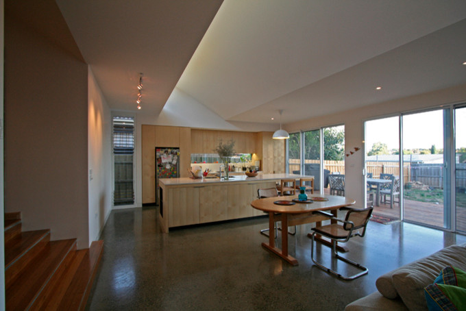 Design ideas for a contemporary eat-in kitchen in Melbourne with light wood cabinets, concrete floors and with island.