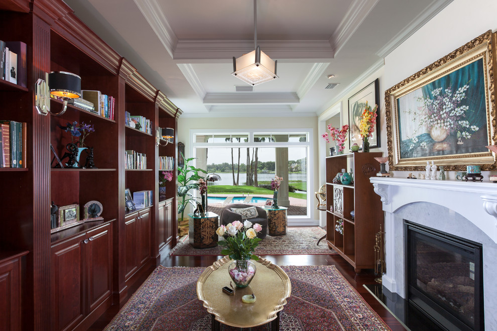 Inspiration for a mid-sized traditional enclosed living room in Orlando with a library, a two-sided fireplace, yellow walls, dark hardwood floors, a stone fireplace surround and no tv.