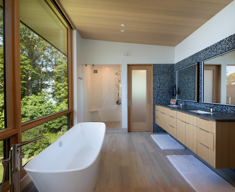 Cette image montre une grande salle de bain principale design avec des portes de placard marrons, meuble double vasque et meuble-lavabo suspendu.