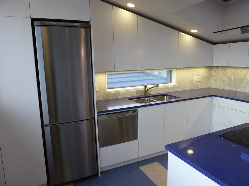 Mid-sized transitional galley porcelain tile kitchen photo in Vancouver with a drop-in sink, flat-panel cabinets, medium tone wood cabinets, marble countertops, green backsplash, ceramic backsplash, stainless steel appliances and an island