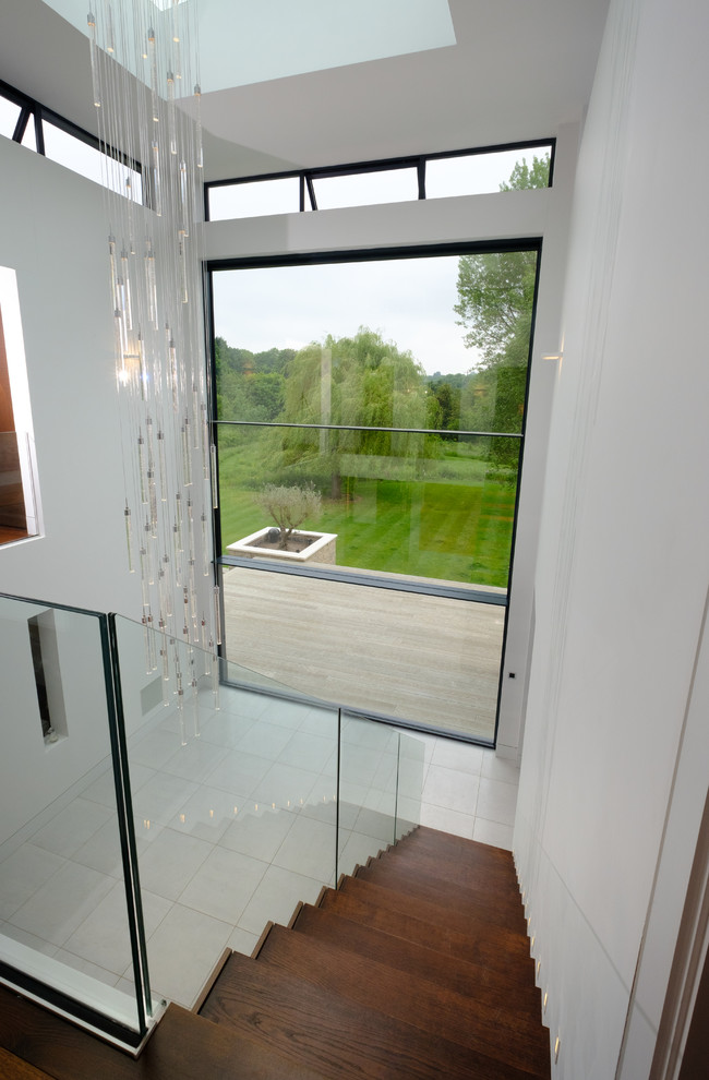 This is an example of a contemporary hallway in Buckinghamshire with white walls, travertine floors and white floor.
