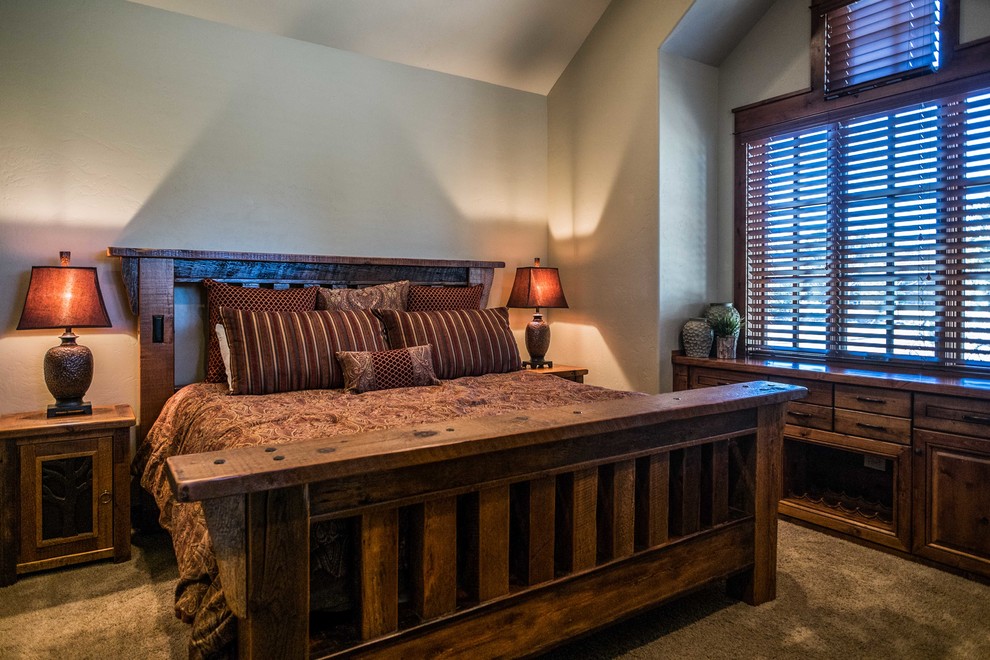 Inspiration for a mid-sized rustic guest carpeted bedroom remodel with beige walls, a corner fireplace and a stone fireplace