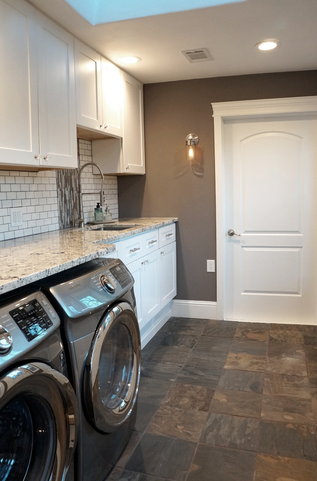 Mid-sized transitional galley dedicated laundry room in Denver with an undermount sink, shaker cabinets, white cabinets, granite benchtops, grey walls, slate floors, a side-by-side washer and dryer and grey floor.