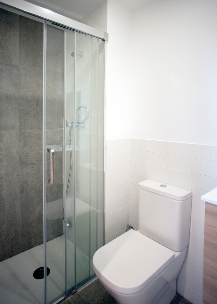 Photo of a mid-sized contemporary master bathroom in Barcelona with medium wood cabinets, a curbless shower, a one-piece toilet, beige tile, beige walls, grey floor, a hinged shower door and white benchtops.
