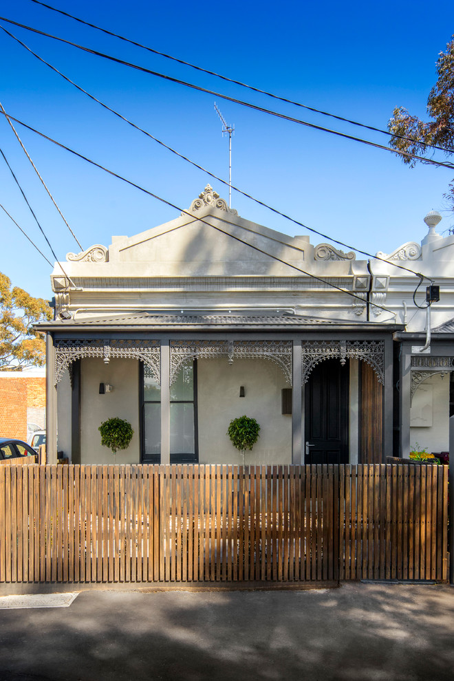 Small traditional two-storey grey exterior in Melbourne with wood siding and a flat roof.