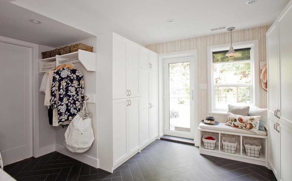 Example of a mid-sized transitional mudroom design in Calgary with a glass front door