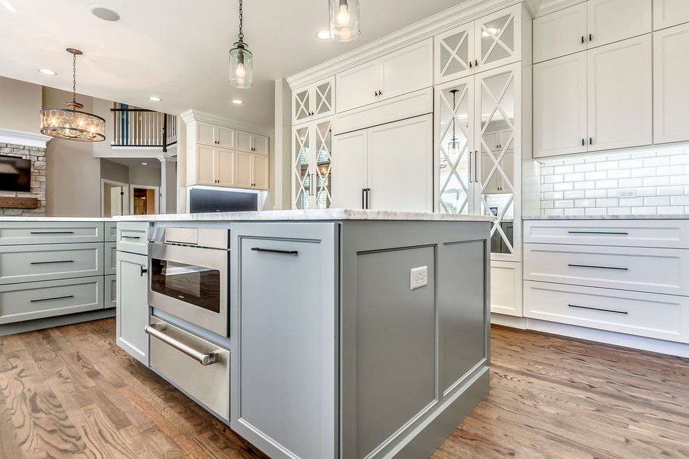 Transitional open concept kitchen photo in Chicago with white backsplash, subway tile backsplash and two islands