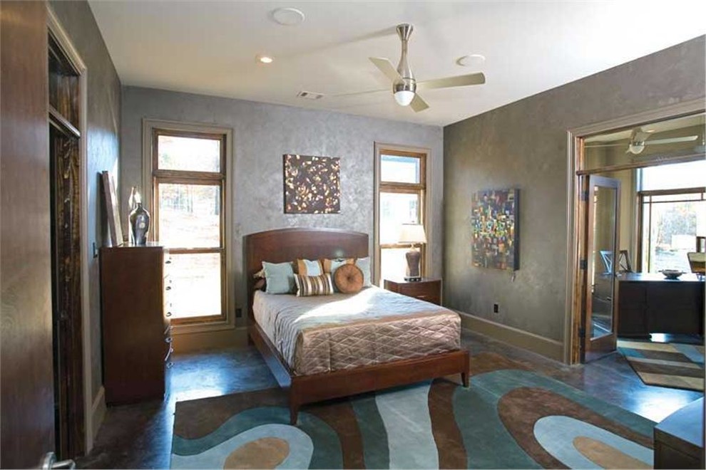 This is an example of a large contemporary master bedroom in New York with grey walls, slate floors and no fireplace.