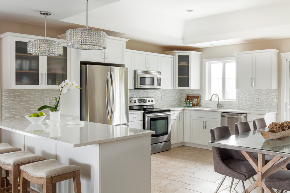 Inspiration for a transitional u-shaped travertine floor and beige floor eat-in kitchen remodel with an undermount sink, shaker cabinets, white cabinets, multicolored backsplash, matchstick tile backsplash, stainless steel appliances and a peninsula