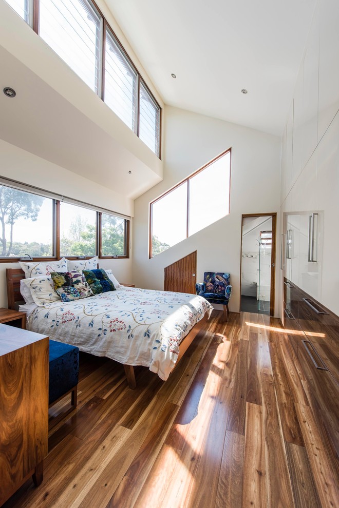 Mid-sized contemporary master bedroom in Melbourne with white walls, medium hardwood floors and no fireplace.