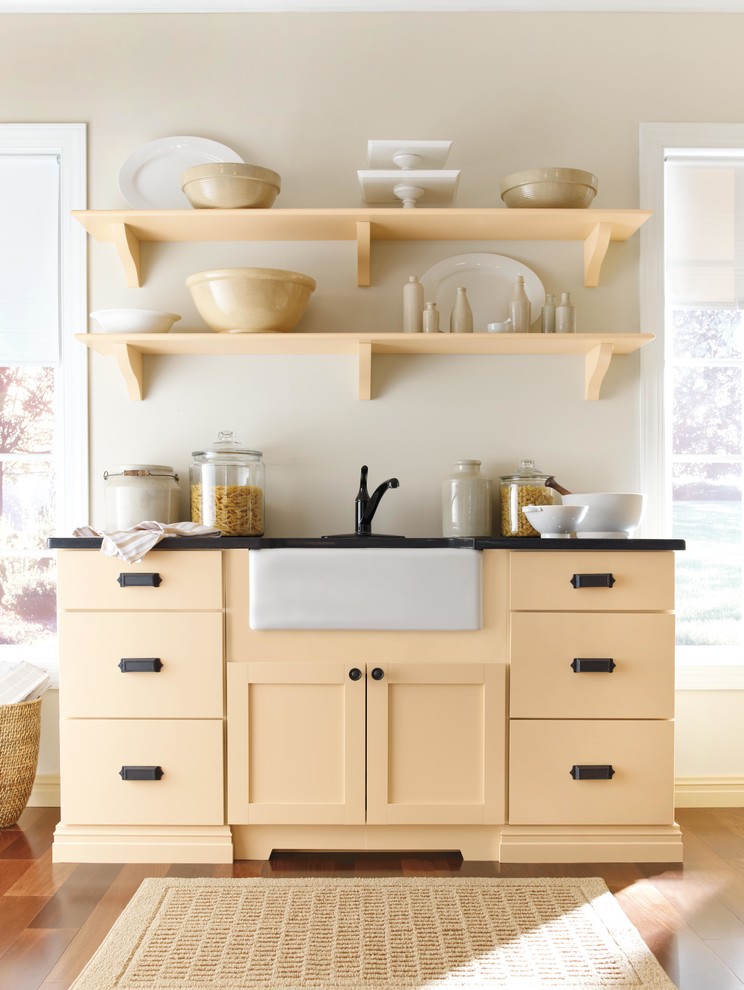 Design ideas for a small country l-shaped eat-in kitchen in New York with shaker cabinets, yellow cabinets, black appliances and medium hardwood floors.