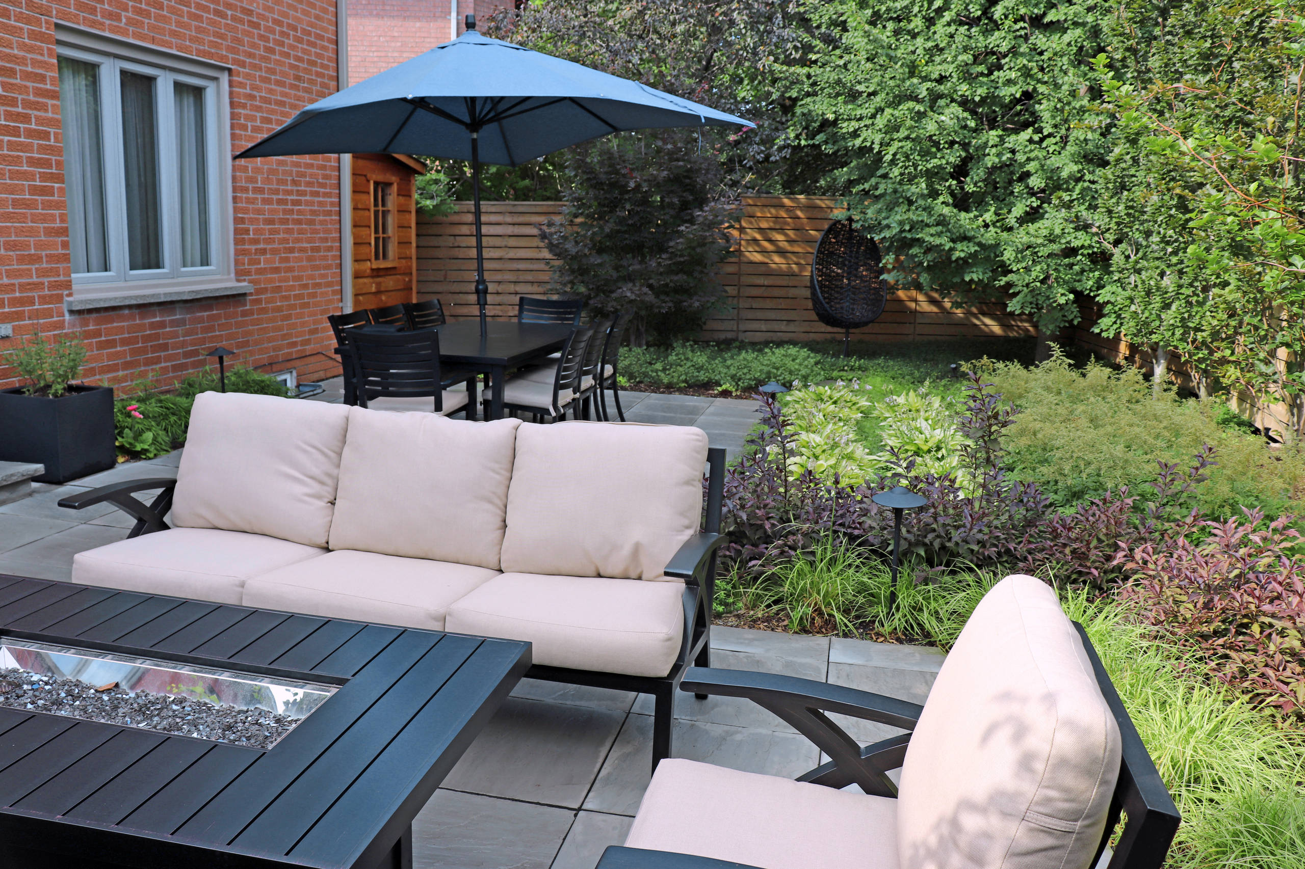 Inspiration for a mid-sized contemporary partial sun backyard stone landscaping in Toronto for summer.