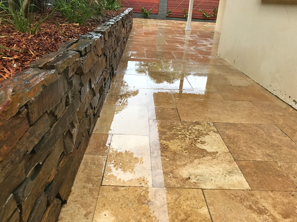 This is an example of a contemporary backyard garden with natural stone pavers.