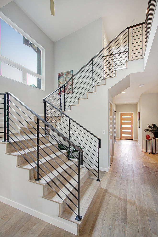 Contemporary wood u-shaped staircase in Seattle with wood risers and metal railing.