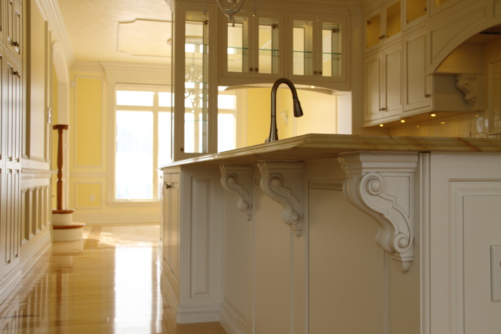Example of a large transitional galley light wood floor eat-in kitchen design with a drop-in sink, beaded inset cabinets, white cabinets, granite countertops, white backsplash, ceramic backsplash, white appliances and an island