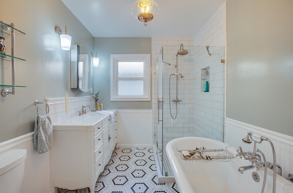 Mid-sized traditional master bathroom in Los Angeles with white cabinets, a claw-foot tub, a corner shower, a one-piece toilet, white tile, subway tile, blue walls, a drop-in sink, marble benchtops, multi-coloured floor, a hinged shower door, white benchtops, a niche, a single vanity, a freestanding vanity, decorative wall panelling and recessed-panel cabinets.