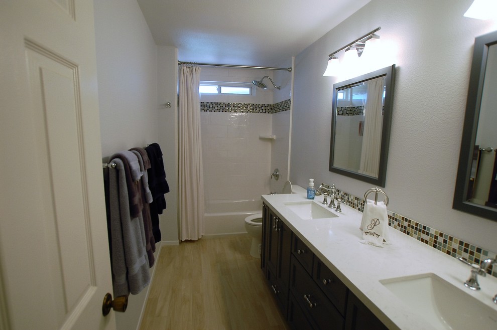 Photo of a small transitional bathroom in San Diego with shaker cabinets, blue cabinets, porcelain floors, a wall-mount sink, quartzite benchtops and beige floor.