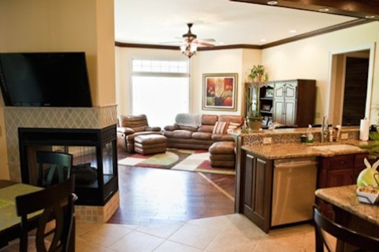 Example of a large galley eat-in kitchen design with a drop-in sink, beaded inset cabinets, medium tone wood cabinets, beige backsplash, stainless steel appliances and an island
