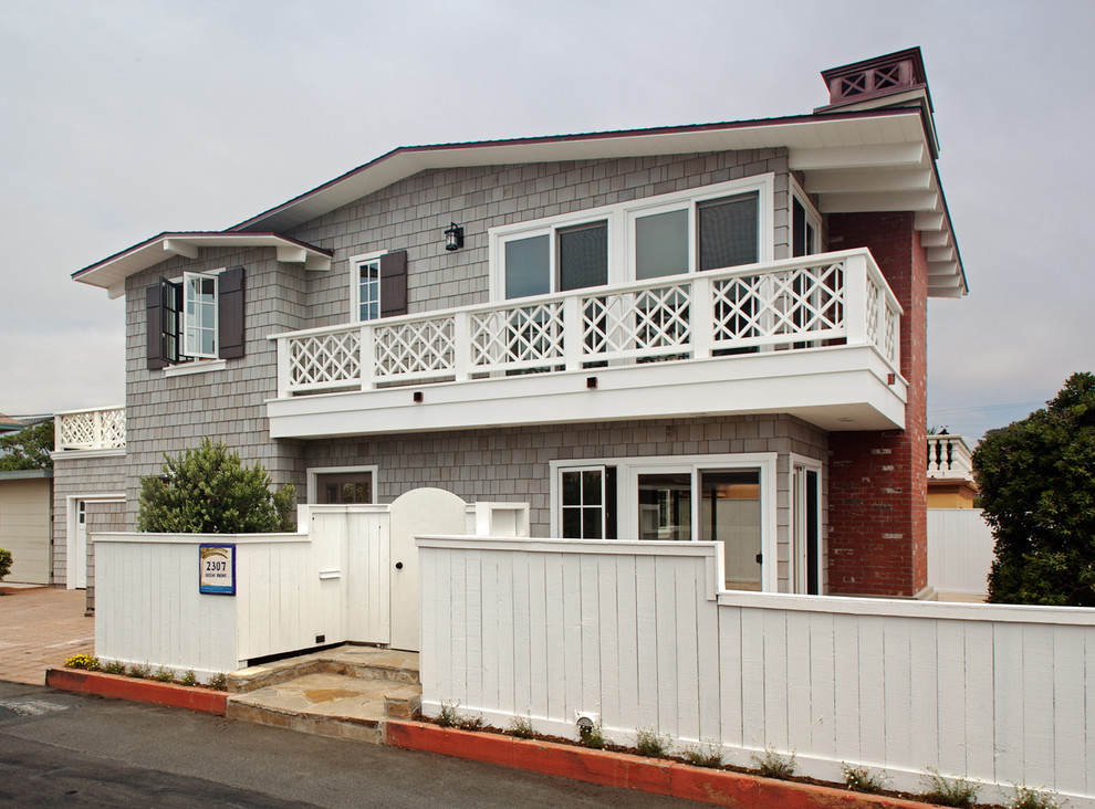 This is an example of a beach style two-storey grey exterior in San Diego with wood siding.