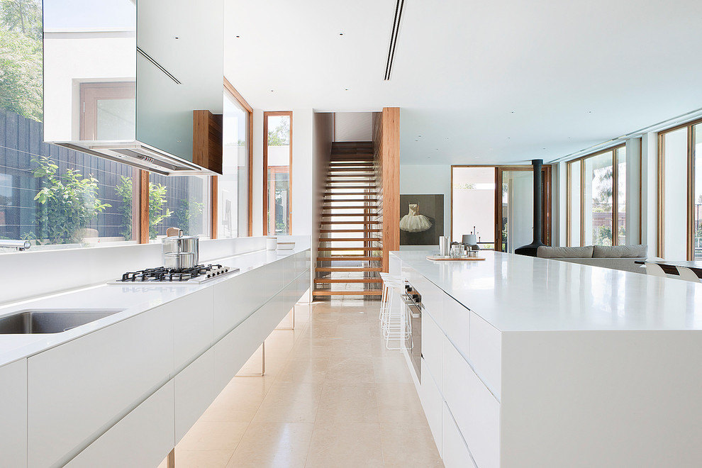 Modern galley open plan kitchen in Melbourne with an undermount sink, flat-panel cabinets, white cabinets, stainless steel appliances and with island.
