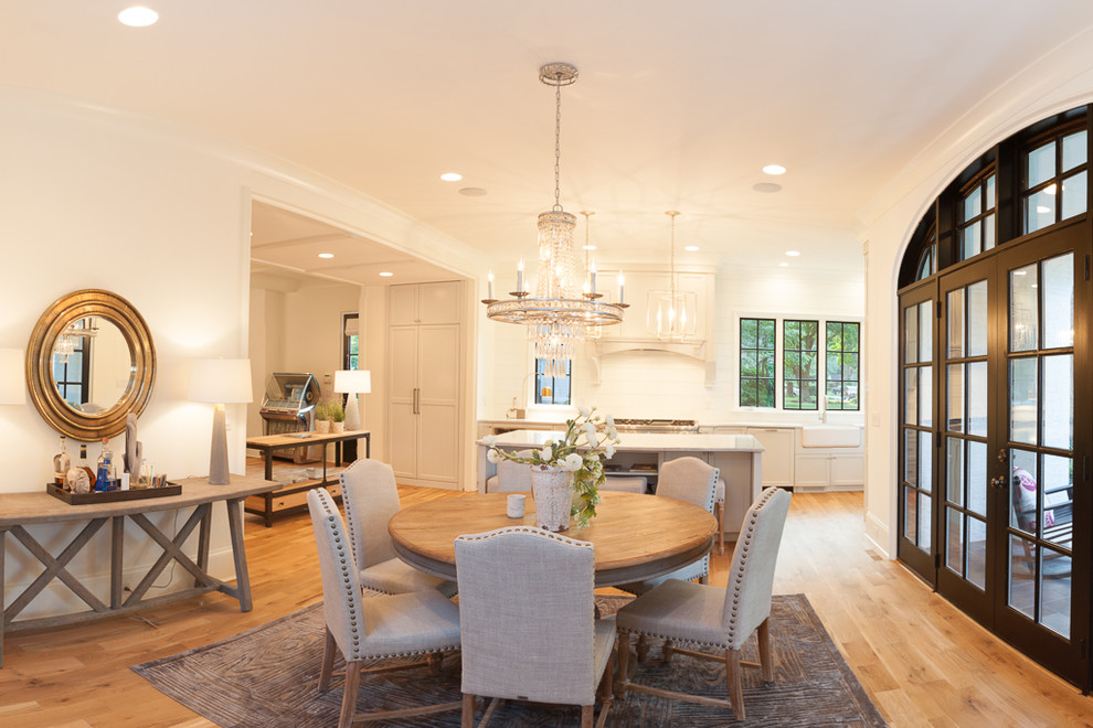 Photo of a large transitional kitchen/dining combo in Charlotte with white walls and light hardwood floors.
