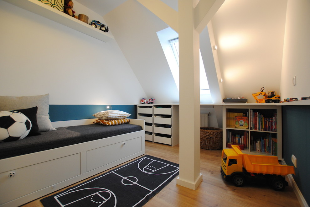 Photo of a mid-sized contemporary kids' playroom for kids 4-10 years old and boys in Berlin with multi-coloured walls, medium hardwood floors and beige floor.