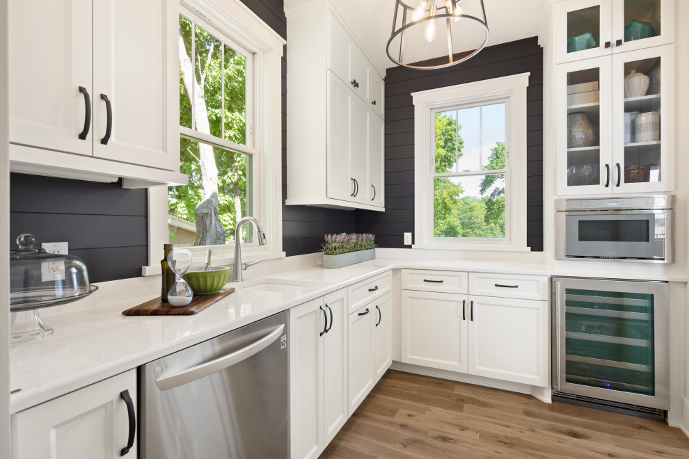 Design ideas for a large transitional u-shaped eat-in kitchen in Minneapolis with a farmhouse sink, shaker cabinets, white cabinets, quartzite benchtops, grey splashback, shiplap splashback, stainless steel appliances, medium hardwood floors, with island, beige floor, white benchtop and vaulted.