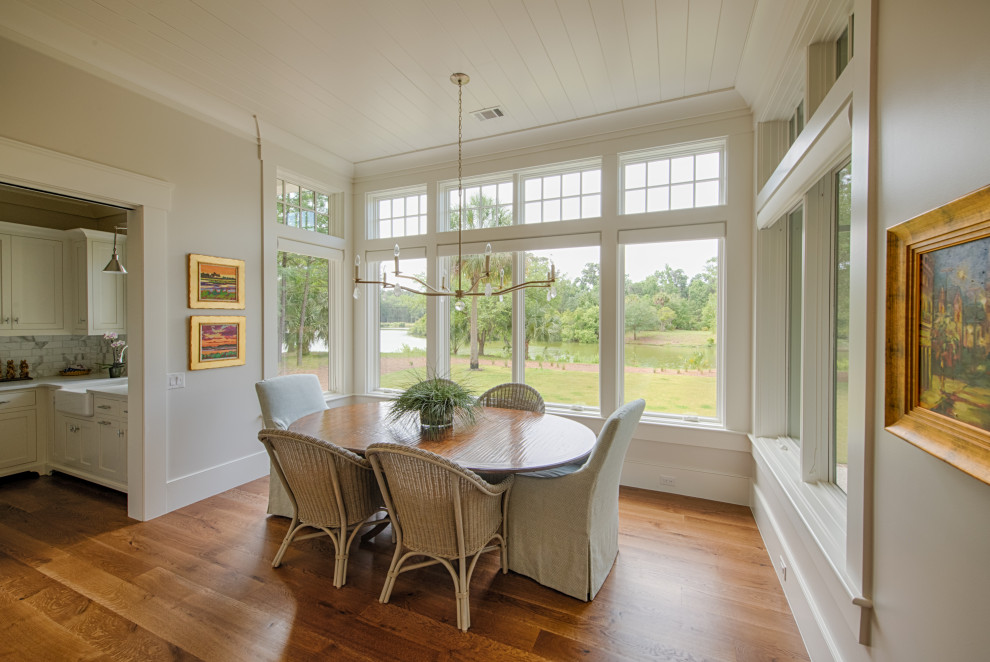 Foto di una sala da pranzo aperta verso la cucina con pareti beige, pavimento in legno massello medio, pavimento marrone e soffitto in perlinato