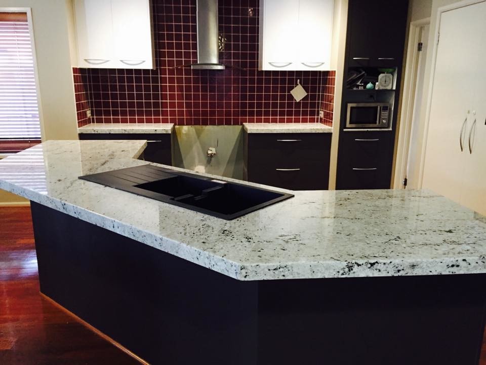 This is an example of a mid-sized modern kitchen in Melbourne with granite benchtops and with island.