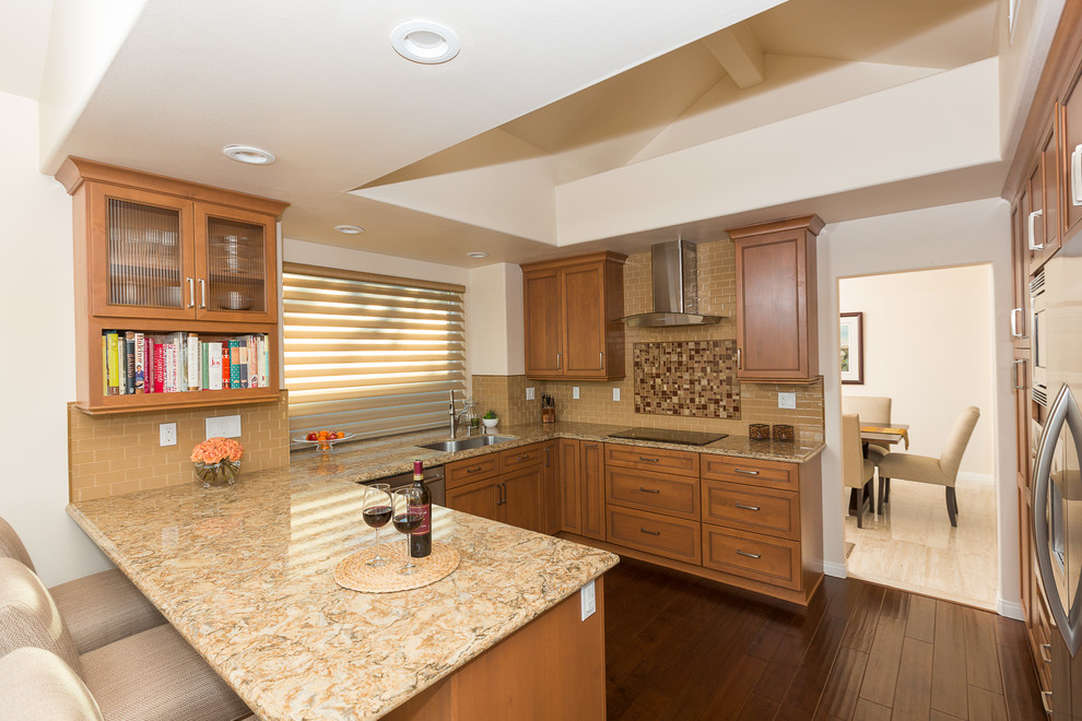 Large transitional u-shaped dark wood floor eat-in kitchen photo in Orange County with a single-bowl sink, raised-panel cabinets, medium tone wood cabinets, granite countertops, beige backsplash, ceramic backsplash, stainless steel appliances and no island